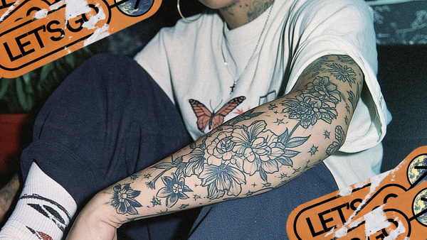 A woman in a white t-shirt with flowery tattoos on her arm