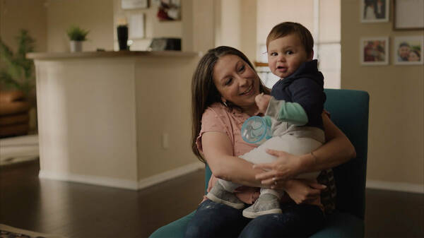 Kyndl Bickers sits in a chair holding her son, Wyatt. 